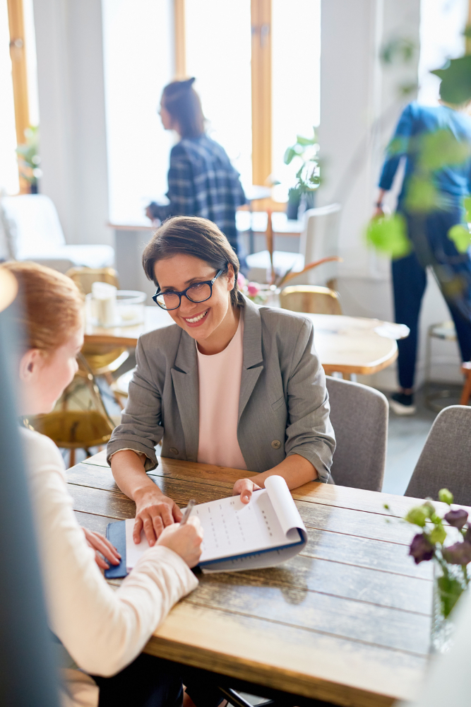 Women engaged in a meeting at a coffee shop, representing advisory in tax planning