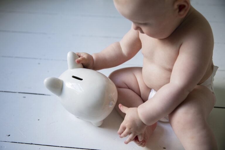 Saving for the future. Cute young baby with a money box