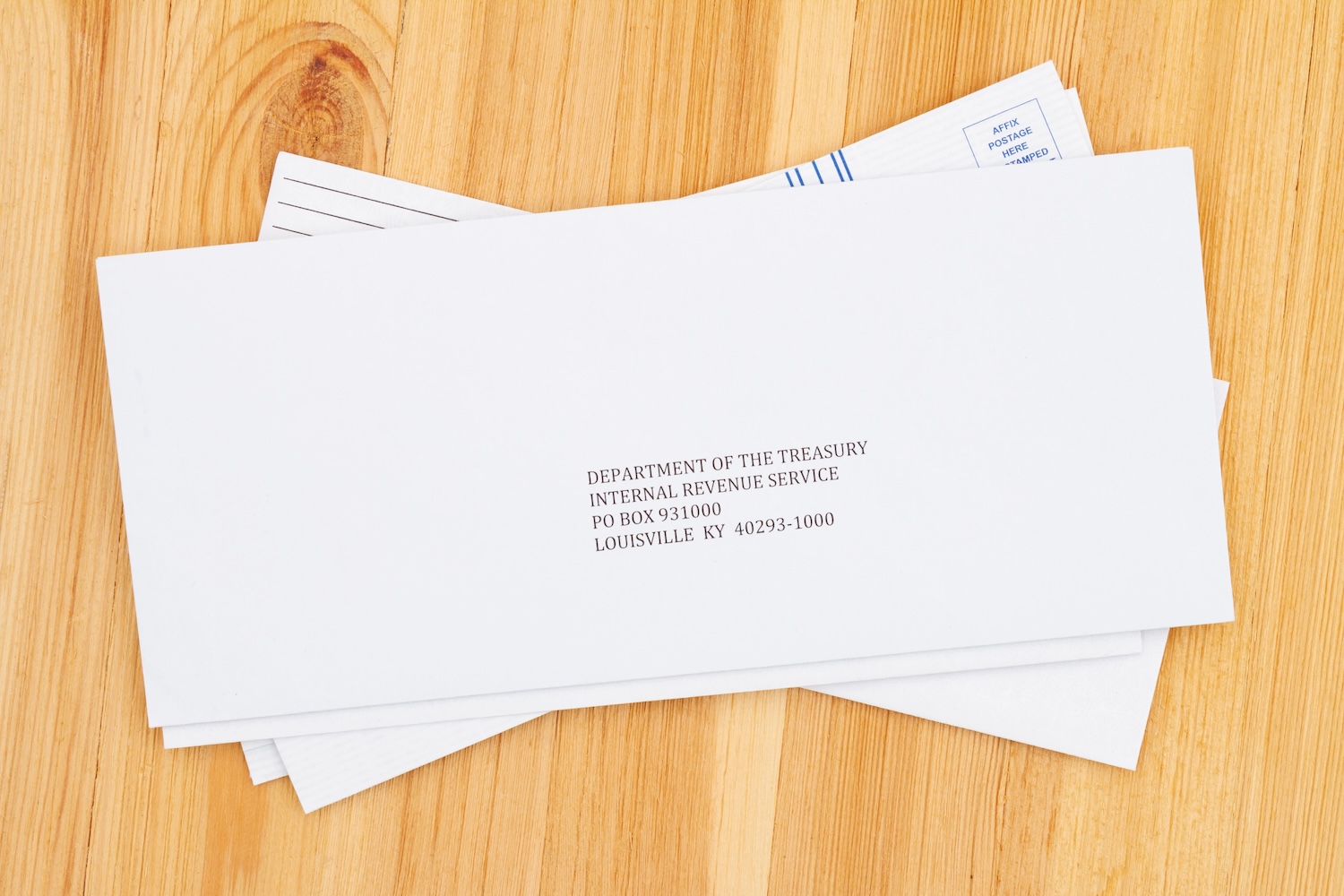 Business envelope addresses to IRS for paying taxes on a wood desk